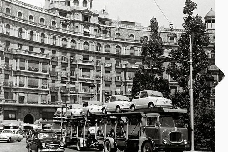Schwarz weiß Aufnahme von 1950 mit einem LKW der mit den ersten SEAT Modellen beladen ist.