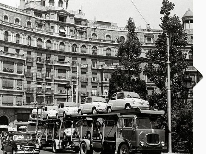Schwarz weiß Aufnahme von 1950 mit einem LKW der mit den ersten SEAT Modellen beladen ist.