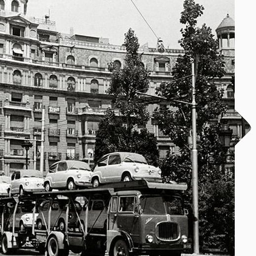 Schwarz weiß Aufnahme von 1950 mit einem LKW der mit den ersten SEAT Modellen beladen ist.